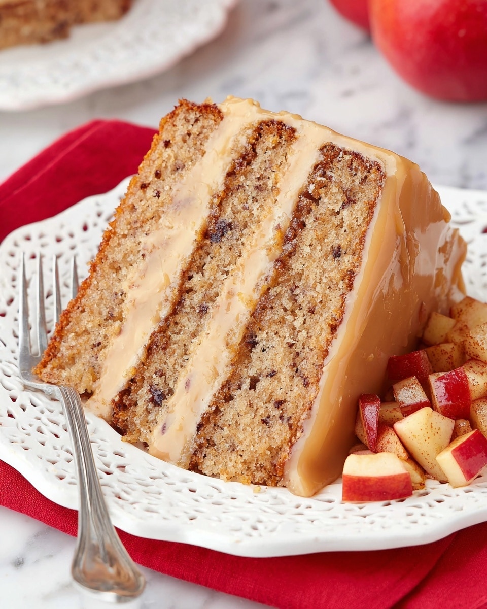 A slice of three-layer cake sits on a white plate with a lace-like edge, showing light brown cake layers speckled with small dark bits, separated by two thick bands of creamy beige frosting. The cake has a moist texture and is topped with a smooth, glossy caramel or glaze. On the right side of the plate, there is a small pile of chopped apples with red skin and a light brown cinnamon coating. A silver fork rests on the left side of the plate, and the scene is set on a white marbled texture with a red cloth underneath the plate. Photo taken with an iphone --ar 4:5 --v 7