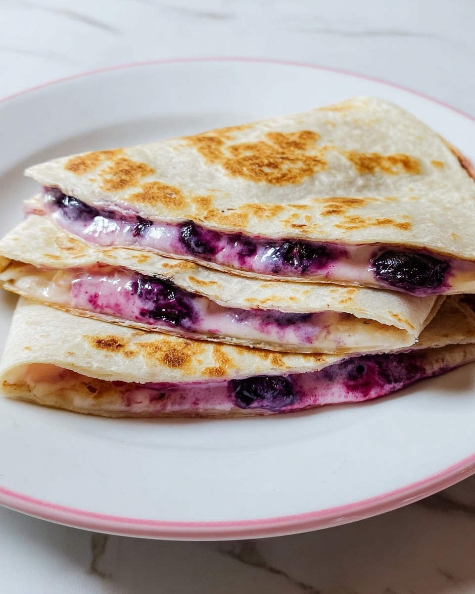 The image shows a white plate with a pink edge, holding a folded quesadilla cut into two visible layers. The quesadilla has a golden-brown toasted outer layer with slightly crispy edges. Inside, there are two layers of creamy and smooth purple filling mixed with whole dark purple blueberry pieces. The quesadilla itself is light beige with a soft texture and some light brown spots from cooking. The plate sits on a white marbled surface. photo taken with an iphone --ar 4:5 --v 7