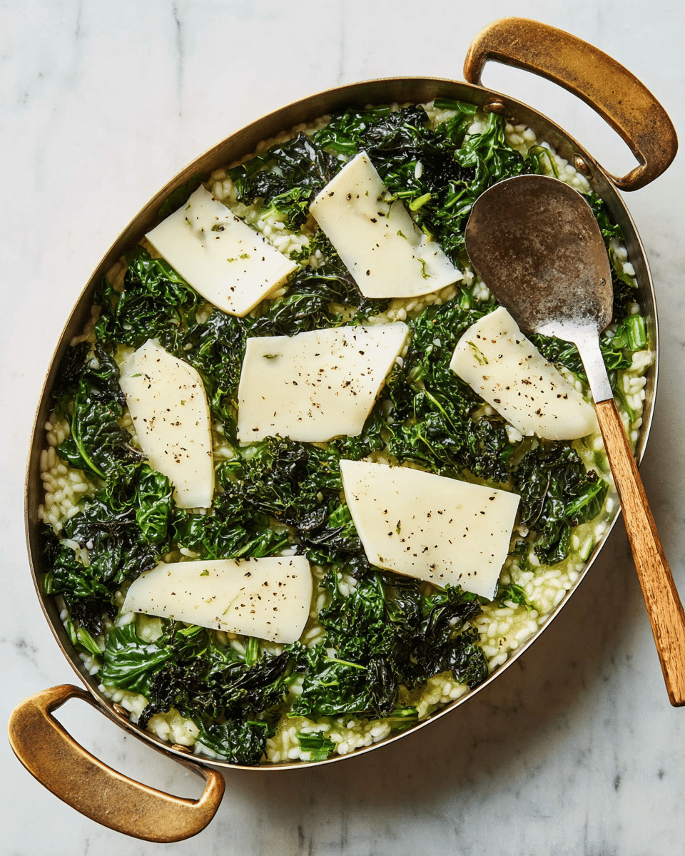 A metal oval pan with two handles holds a layered dish on a white marbled surface. The first layer is green risotto with a moist, creamy texture filling the whole pan. On top, large dark green kale leaves, slightly wilted and shiny, are scattered evenly across the dish. Thin, wide slices of white cheese are placed over the kale, sprinkled with small black pepper flakes. A fork with a wooden and brass handle rests inside the pan on the right side. Photo taken with an iphone --ar 4:5 --v 7