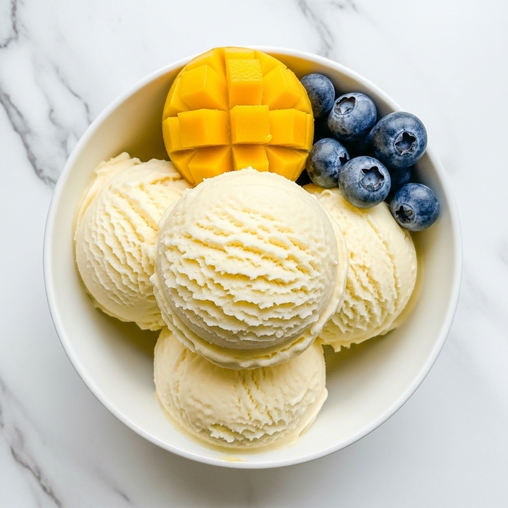 A close-up view of a glass jar filled with a soft, crumbly, pale yellow substance that looks creamy and slightly grainy. Inside the jar, there is a metal spoon scooping a generous amount of this thick, textured mixture, showing its dense yet smooth consistency. The background is softly blurred with a white marbled texture and a light beige cloth visible in the upper part of the image. Photo taken with an iphone --ar 4:5 --v 7