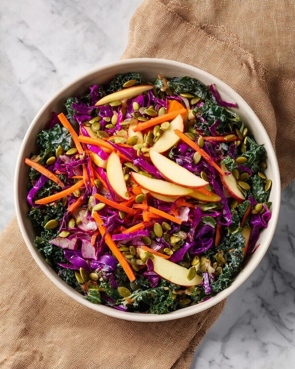 A white bowl is filled with a colorful salad made of multiple layers. The base layer consists of dark green chopped kale mixed with thin strips of deep purple cabbage. Bright orange carrot sticks are scattered evenly on top, followed by thin, pale yellow apple slices. Light green pumpkin seeds are sprinkled throughout, adding texture and contrast. The salad's textures vary from crisp to crunchy, with vibrant natural colors all mixed together. The bowl rests on a white marbled surface, with a light brown cloth napkin beside it. photo taken with an iphone --ar 4:5 --v 7
