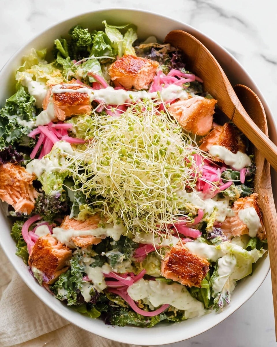 The image shows a close-up view of a fresh salad in a white bowl, filled with multiple layers of ingredients. The bottom layer is made of bright green leafy lettuce with different textures, followed by shreds of white cheese scattered throughout. There are pink pickled onion slices spread on top, adding color contrast. Small pieces of light orange salmon are mixed in, coated with creamy white dressing that has green specks of herbs. Two wooden spoons are seen mixing the salad, with a woman's hand holding one on the side. The background is a white marbled surface. Photo taken with an iphone --ar 4:5 --v 7