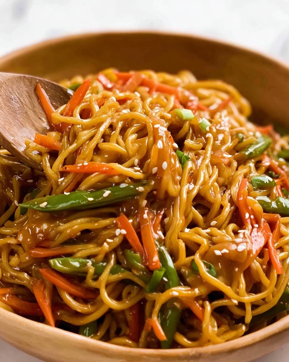 A close-up of a bowl filled with glossy, golden yellow noodles mixed with thin, bright orange carrot strips and green beans cut into small sections, all coated evenly with a shiny, brown sauce. There are small white sesame seeds sprinkled on top, and bits of green onion sliced thinly and scattered throughout. A wooden spoon rests in the bowl, partially lifting some of the noodles. The dish sits on a white marbled surface. photo taken with an iphone --ar 4:5 --v 7