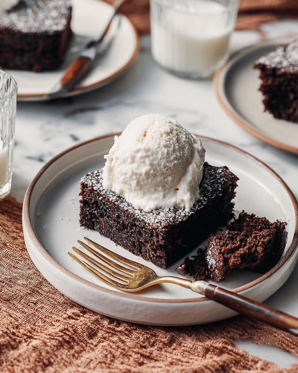 A square piece of chocolate brownie sits on a white plate, its dark brown top scattered with glistening sugar crystals, creating a slightly rough texture. The brownie looks thick and moist with a dense chocolatey inside that contrasts with the lighter sugar on top. Next to the brownie on the plate is a gold-tipped fork with a dark wooden handle. Around the main plate, there are three more white plates each holding a similar square brownie, and two transparent glasses filled halfway with frothy milk rest nearby. The setting is on a white marbled surface with a folded brown cloth visible at the corner. Photo taken with an iphone --ar 4:5 --v 7