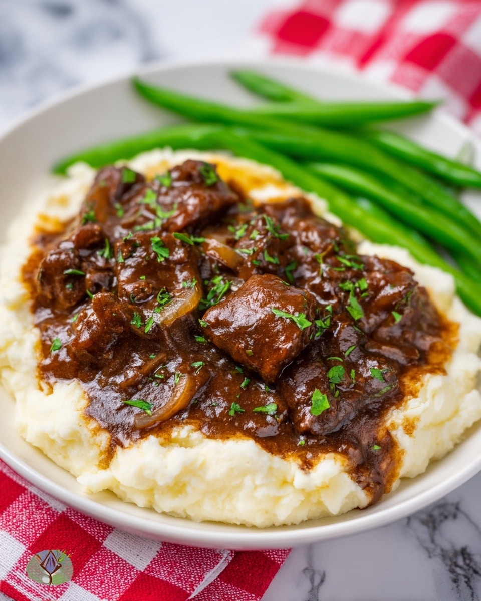 A white plate holds a three-layer dish starting with a smooth, creamy white layer of mashed potatoes spread flat, topped by a thick layer of dark brown beef stew with shiny chunks of beef and onions in rich gravy, sprinkled lightly with green chopped herbs. On one side of the plate, bright green cooked green beans lay in a neat pile. The plate sits on a white marbled surface with a red and white checkered cloth partially under it. Photo taken with an iphone --ar 4:5 --v 7