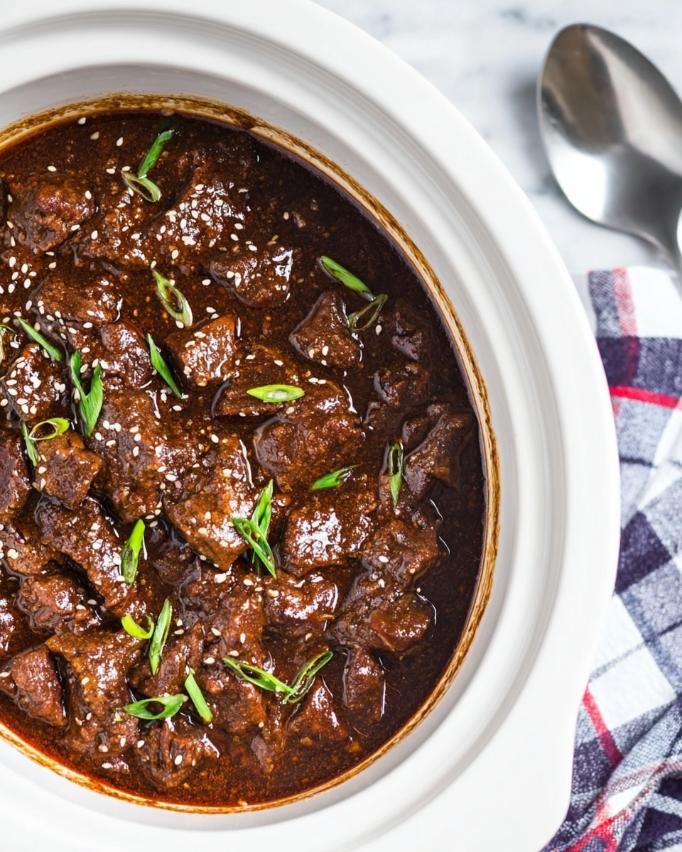 The image shows a white slow cooker filled with a rich, dark brown stew made of tender beef chunks covered in a glossy sauce. Small white sesame seeds and chopped green onions are sprinkled on top, adding texture and color contrast. The surface of the stew has small bubbles of oil, giving it a shiny look. The slow cooker sits on a white marbled texture with a blue, white, and red checkered cloth underneath, and there is a silver spoon resting nearby. photo taken with an iphone --ar 4:5 --v 7