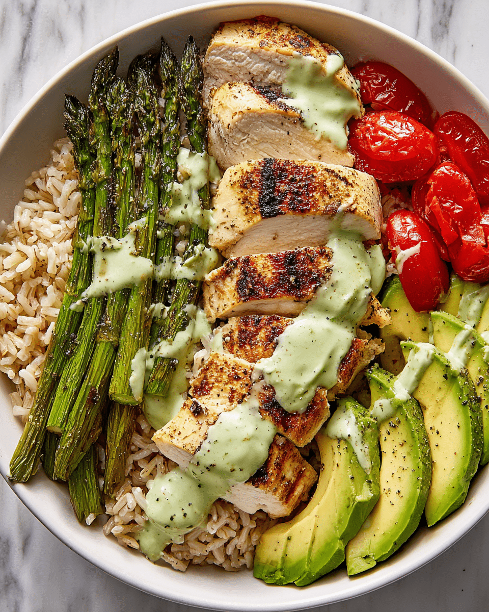 A white bowl filled with a base layer of light brown cooked rice, topped with four pieces of golden-brown grilled chicken breast, sliced and placed on one side. Next to the chicken are bright green grilled asparagus spears, slightly charred. On the other side, there are red cherry tomato halves and slices of fresh green avocado, all sprinkled with black pepper. The entire bowl is drizzled with a creamy light green sauce. The bowl is set on a white marbled surface. photo taken with an iphone --ar 4:5 --v 7