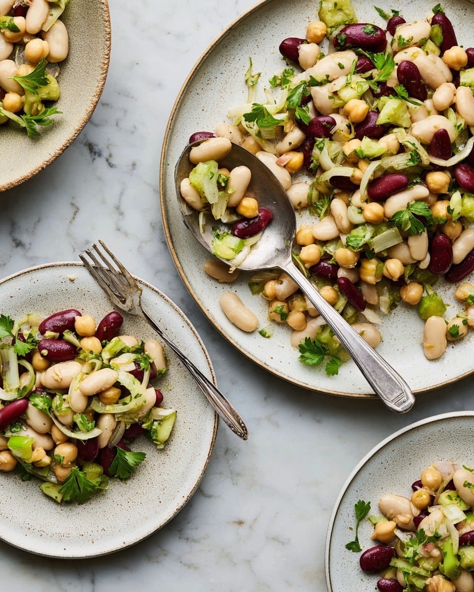 The image shows a bean salad served on three white plates with one large plate on the top right and two smaller plates at the bottom right and left. The salad has three types of beans: cream white cannellini, dark red kidney beans, and beige chickpeas, mixed evenly. Thin slices of light green celery and thin rings of pale purple onion are scattered throughout. Fresh green parsley leaves add a pop of color with their bright, leafy texture. A large metal spoon rests on the big plate, partially covered with the salad, and a silver fork lays on the plate at the bottom left. The background is a white marbled surface that contrasts softly with the salad color. photo taken with an iphone --ar 4:5 --v 7