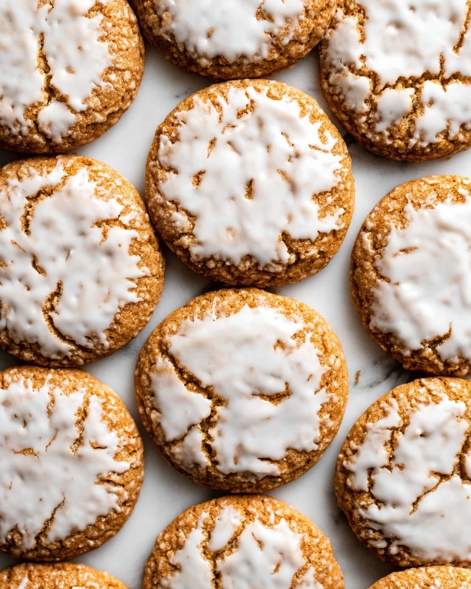 A close-up view of several round cookies arranged side by side on a white marbled surface, showing one layer with a golden-brown textured base and a thin, unevenly spread layer of smooth white icing on top. The icing displays natural cracks and gaps, allowing the cookie underneath to show through in places, creating an organic pattern across the surface. The cookies have soft edges and a slightly raised appearance, filling the frame with their warm and inviting tones. Photo taken with an iphone --ar 4:5 --v 7