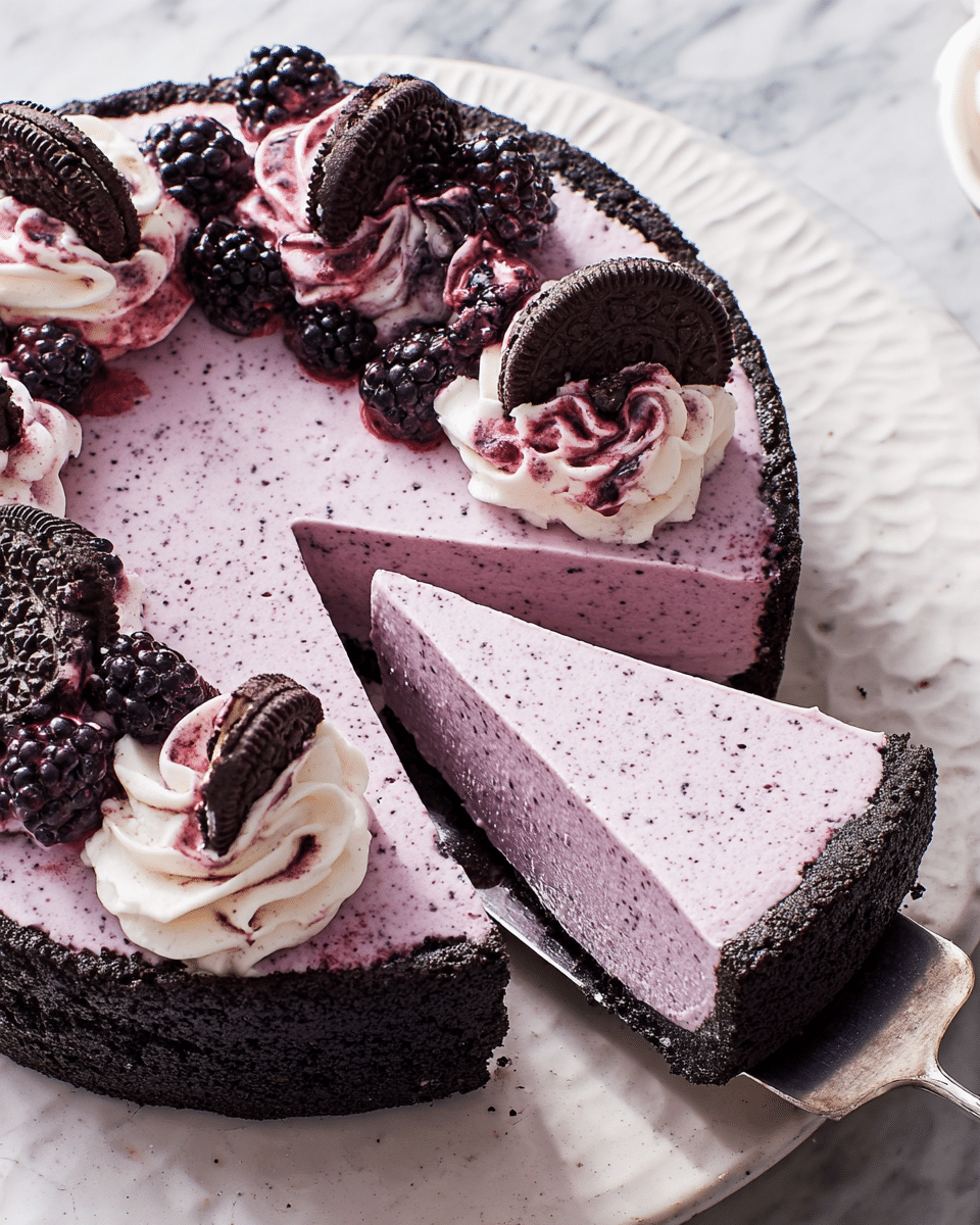 A smooth, light purple cheesecake with tiny specks sits on a dark chocolate crumb crust that lines the round tart pan with a scalloped edge. One slice is cut out and lifted by a metal spatula, showing the cake's firm but creamy texture. The top of the cheesecake is garnished with two layers of creamy white whipped topping swirled with dark purple berry sauce, covered with whole blackberries and small chocolate sandwich cookies. The cheesecake is placed on a round white plate with a subtle texture, all set on a white marbled surface. Photo taken with an iphone --ar 4:5 --v 7