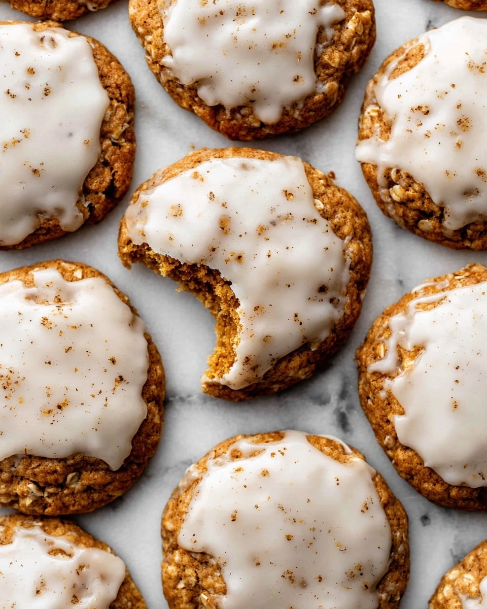 Several round cookies with a rough, golden-brown base layer are spread out on a white marbled surface, each topped with a glossy, uneven layer of white icing that drips slightly over the edges. The icing has small specks of brown sprinkled lightly on top, adding texture and detail. One cookie near the center has a bite taken out, showing the rough crumbly inside beneath the smooth icing. The cookies are arranged closely, filling the frame. photo taken with an iphone --ar 4:5 --v 7