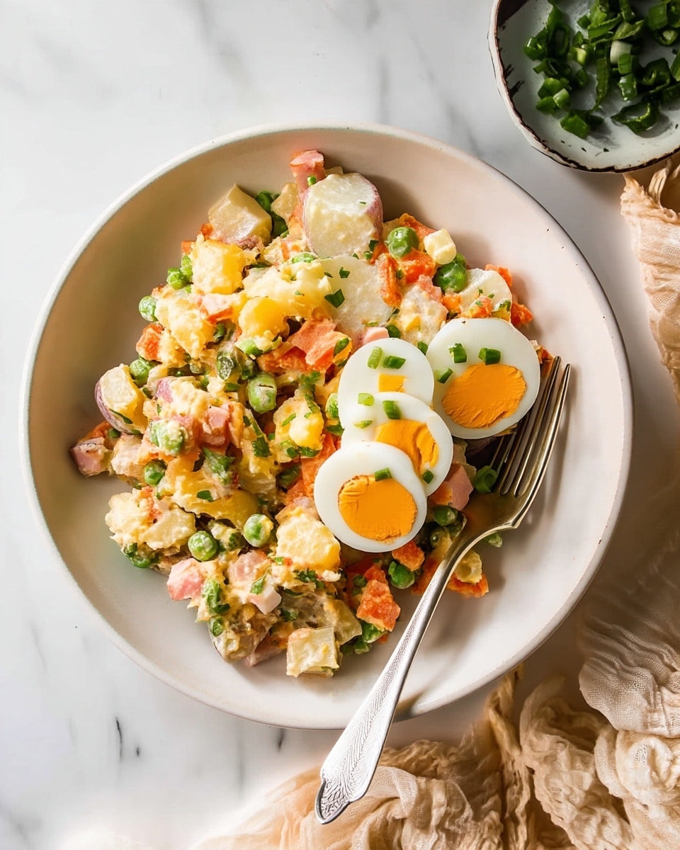A white bowl filled with a colorful potato salad mixed with diced orange carrots, white potatoes, green peas, and small bits of green herbs, all coated in a creamy dressing. On top, three slices of hard-boiled egg with bright orange yolks are neatly placed, sprinkled with chopped green onions. A silver fork rests inside the bowl on the right side. In the upper right corner, a small white bowl holds extra chopped green onions. The scene is set on a white marbled surface with a light beige cloth draped around the bottom and right edges. photo taken with an iphone --ar 4:5 --v 7