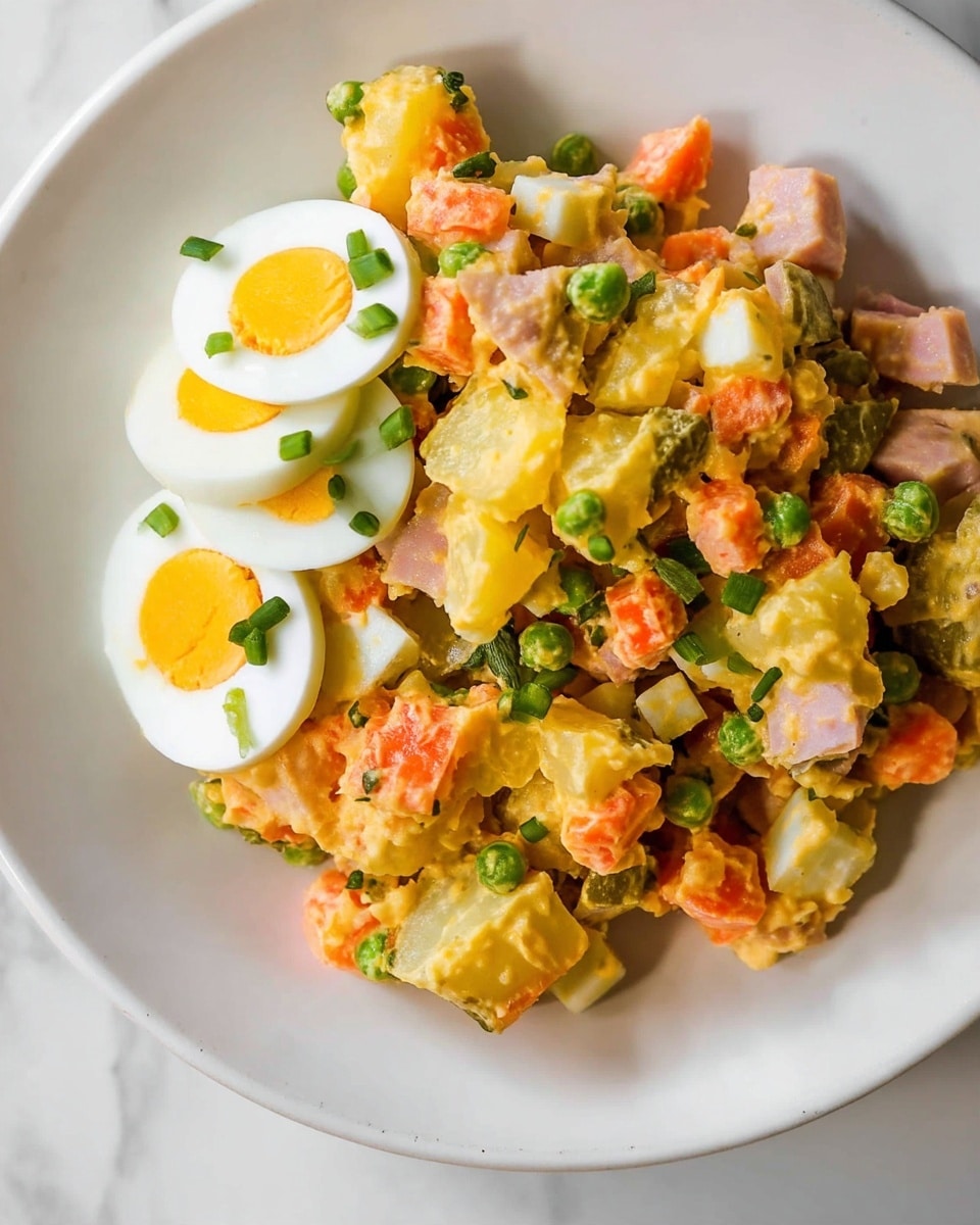 The image shows a close-up view of a white plate filled with a chunky salad made of small, rough pieces of yellow potatoes, orange carrots, pale green pickles, and small bits of white boiled egg, all mixed together with a creamy dressing. There are also small pieces of what looks like ham or chicken scattered throughout the salad. On one side of the plate, there are three slices of boiled egg with bright yellow yolks, garnished with chopped green onions sprinkled over the salad and eggs. The plate rests on a white marbled surface with part of a beige cloth visible beside it. Photo taken with an iphone --ar 4:5 --v 7